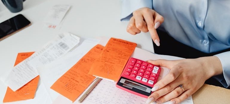 Woman using a calculator while calculating moving costs for moving from Alexandria to Lanham.