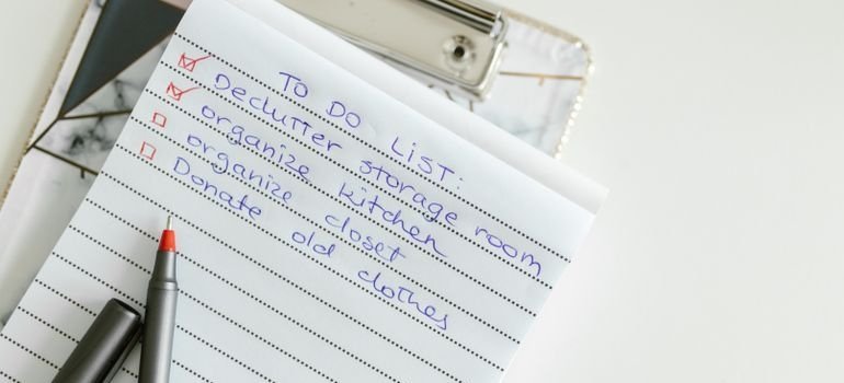 Person making a to do list in their notebook.