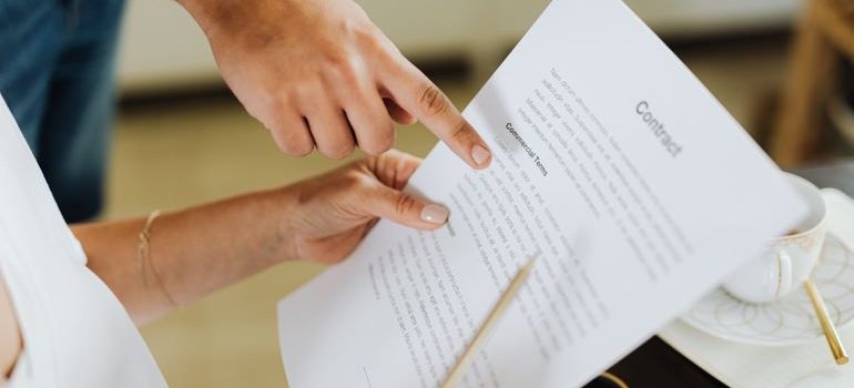 Person reading a contract in order to avoid moving scams.