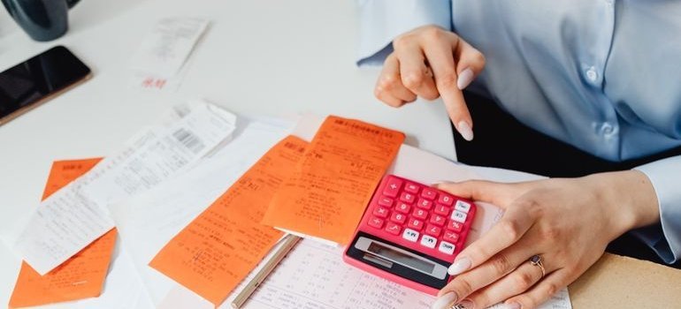 Woman calculating costs when researching cheapest states to live in.