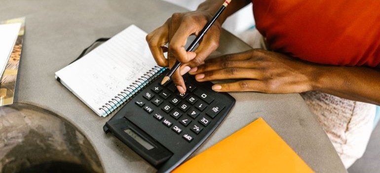 Woman using a calculator to calculate moving costs.