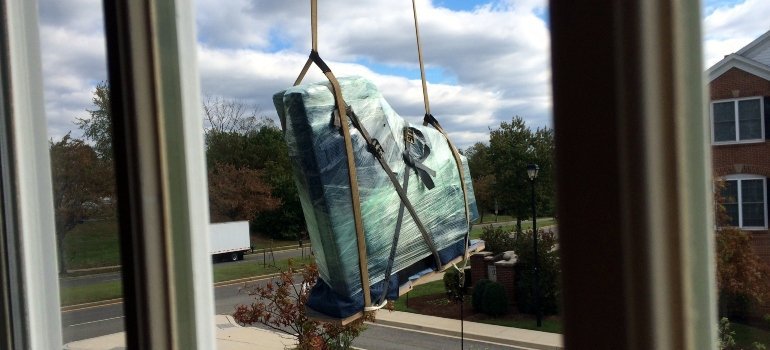 Piece of furniture being airlifted out of a house.