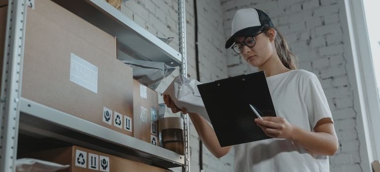 Woman writing an inventory to choose the right storage unit size.